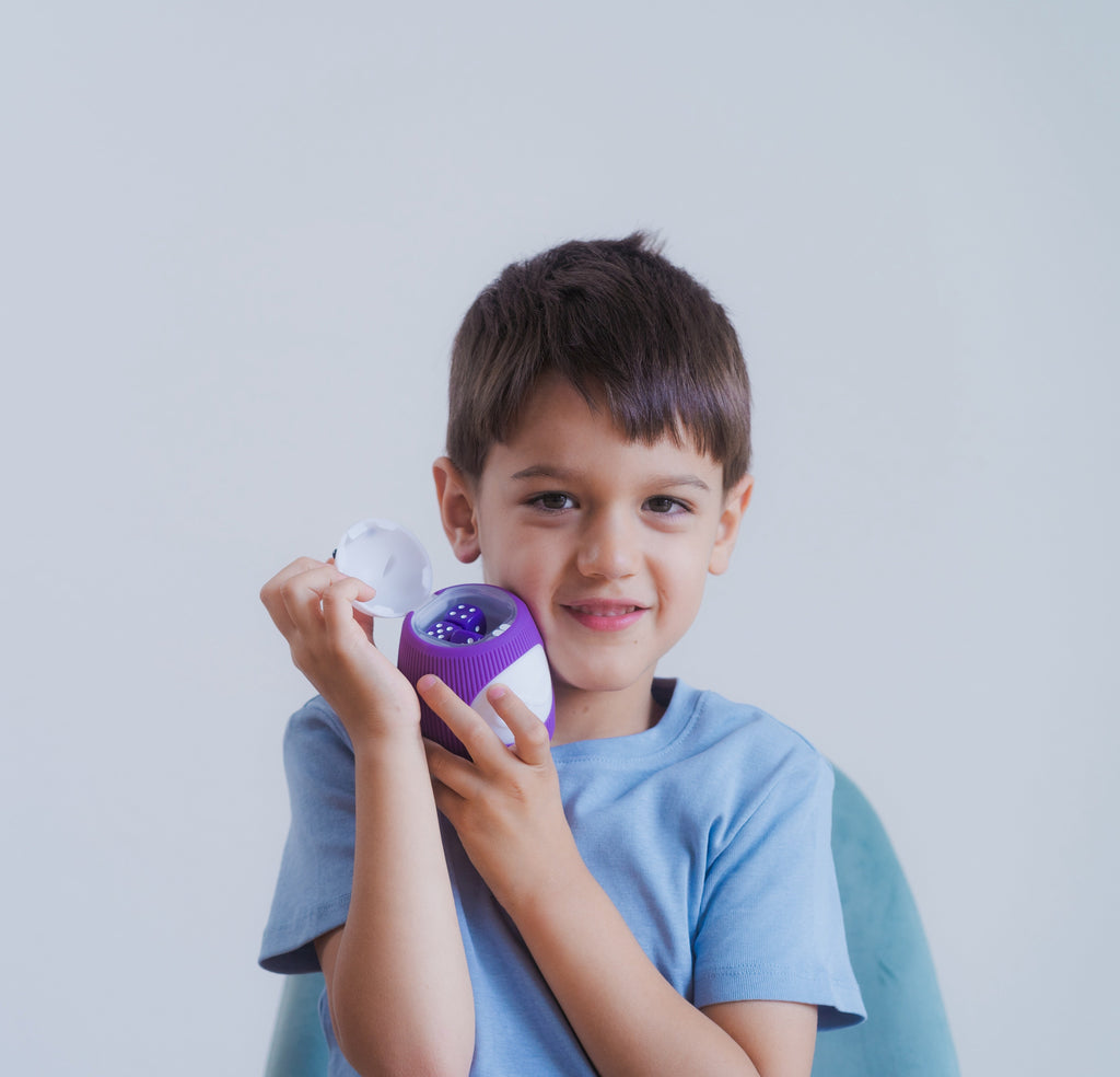 A smiling preschool-aged boy is holding an open TukToro figure in his arms and pressing it against his cheek.