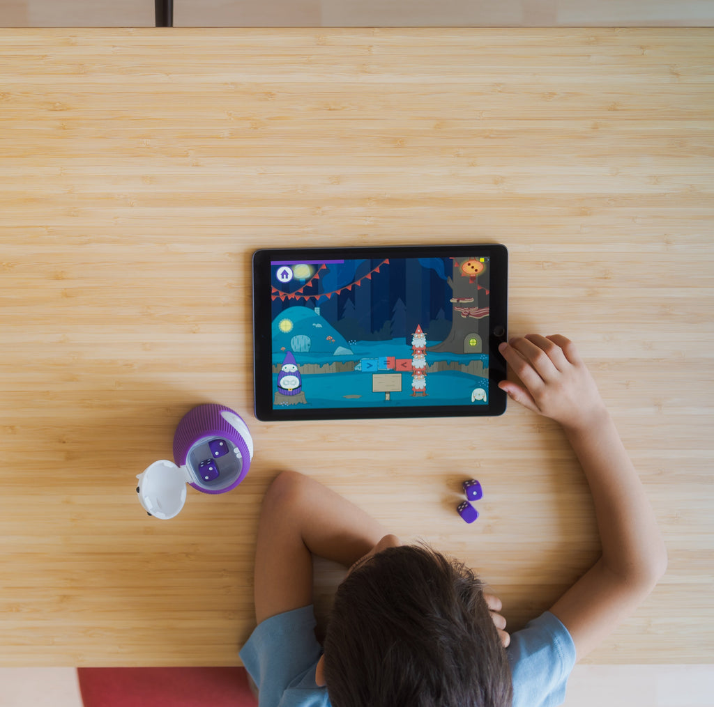 Child uses the TukToro haptic learning toy and a tablet to solve math problems.